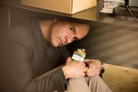 Merz gegen Merz – So muss Erik (Christoph Maria Herbst) den letzten Tag in seinem Büro verbringen: Zusammengekauert unter seinem Schreibtisch lauscht er einem Gespräch von Anne (Annette Frier) und Vera (Charlotte Bohning).