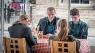 The Bay – Lisa Armstrong (Morven Christie, l.v.) und ihre beiden Kinder Rob (Art Parkinson, r. h.) und Abbie (Imogen King, r.v.) treffen sich gemeinsam mit Andy Warren (Joe Absolom, l.h.) in einem Restaurant. Das Familienglück täuscht jedoch.