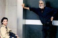 Der Haneke-Code – Michael Haneke mit Juliette Binoche während der Dreharbeiten zu „Code: unbekannt“: Haneke drückt mit seinen Filmen auf die Stellen, wo es weh tut, bringt Schattenseiten und verdrängte Gefühle ans Tageslicht und stellt den Menschen so dar, wie er ist.