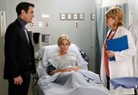 Modern Family – Phil (Ty Burrell) hat Claire (Julie Bowen, M.) nach ihrer Ohnmacht ins Krankenhaus gebracht, wo sich zum Glück herausstellt, dass sie nichts Ernstes hat. Dr. Coben (Beverly Leech) rät jedoch, dass Claire sich schonen soll.