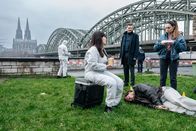 SOKO Köln – Jan Meyers (Anselm Ferdinand Bresgott, liegend), ein bekannter Straßenmusiker, wird tot am Rheinufer aufgefunden. Gemeinsam mit der Rechtsmedizinerin Dr. Pilar Westphal (Yulia Yáńez Schmidt, 2.v.l.) rätseln die Kommissare Amira Mahdi (Aylin Ravanyar, r.) und Jonas Fischer (Lukas Piloty, Mi.), was passiert ist. (Komparsen im Bild)