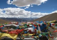 Straße der Achttausender – Die Achttausender Makalu, Lhotse, Everest und Shisapangma sind am Horizont hinter den Gebetsfahnen zu erkennen.