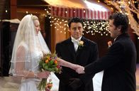 Friends – Da der Pfarrer in einem Schneesturm stecken bleibt, übernimmt Joey (Matt LeBlanc, M.) die Trauung von Phoebe (Lisa Kudrow, l.) und Mike (Paul Rudd, r.) ...