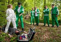 Hubert und Staller – Sonja Wirth (4.von rechts) hat beim Dienstsport nach wenigen Metern eine Leiche im Unterholz entdeckt. Dr. Anja Licht (Karin Thaler, links) diskutiert mit Staller (Helmfried von Lüttichau, 2.von links) über die mögliche Mordwaffe, während die anderen geschockt sind über den Fund der Leiche. (Paul Sedlmeier, Christian Tramitz, Michael Brandner, von rechts).