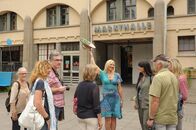 SOKO Stuttgart – Freudig begrüßt Touristenführerin Elke Kettler (Tanja Kuntze, 4.v.r.) eine neue Besuchergruppe, die sie durch die Markthalle führen wird.