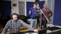 Checker Julian – Julian (Mitte) und der Synchronsprecher und Dialekt-Imitator Oliver Lehmann (re.) synchronisieren in einem Münchner Tonstudio Ausschnitte aus Julians Sendungen im Dialekt.