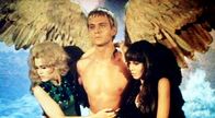 Barbarella – Pygar(John Phillip Law) entschwebt dem lasterhaften Chaos, mit Barbarella (Jane Fonda, li.) und der schwarzen Königin (Anita Pallenberg, re.) in den Armen.