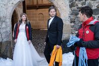 Die Bergretter – Inmitten eines Hochzeitsfoto-Shootings geht ein Notruf ein. Für Katharina (Luise Bähr, l.) und Markus (Sebastian Ströbel, M.) bleibt keine Zeit für ein Outfit-Wechsel. Rudi (Michael Pascher, r.) traut seinen Augen kaum.