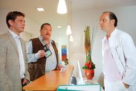 Die Rosenheim-Cops – Die Cops Korbinian Hofer und Christian Lind befragen Dr. Balzer, den Kollegen des ermordeten Zahnarztes (v.li.: Tom Mikulla, Joseph Hannesschläger, Martin Brambach).