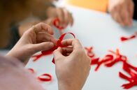 I saw the Sign – AIDS-Schleifen wurden oft in Gruppen, sogenannten Ribbon Bees, hergestellt.