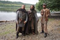 Schottland - Kampf der Clans – Robert Bruce (David Paisley) wartet mit seinen Verbündeten Neil Campbell (Callum Paul) und Edward Bruce (Dòmhnall Eòghainn MacKinnon) auf ein Boot, das ihn retten soll, nachdem er knapp einem Hinterhalt entkommen ist.