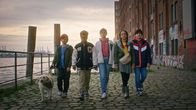 Die Pfefferkörner – Der erste Fall ist gelöst! Selbstbewusst zeigen sich Piet (Noah Lusander) mit Hund Bagel, Kofi (Mathieu Noël), Malin (Ida Carlo), Taara (Josefine Maxima) und Jules (Tibet Held).