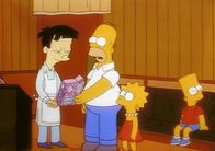 Die Simpsons – Homer (2.v.li.) fragt den Japaner Akira (li.), was auf der Packung mit seinem Konterfei steht.