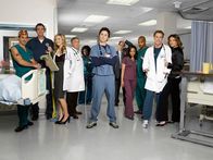 Scrubs - Die Anfänger – Die Truppe vom Sacred Heart Hospital: (v.l.n.r.) Dr. Todd Quinlan (Robert Maschio), Hausmeister (Neil Flynn), Elliot (Sarah Chalke), Dr. Bob Kelso (Ken Jenkins), Schwester Laverne Roberts (Aloma Wright), J.D. (Zach Braff), Ted Buckland (Sam Llyod), Carla (Judy Reyes), Turk (Donald Faison), Dr. Phil Cox (John C. McGingley) und Jordan Sullivan (Christa Miller)