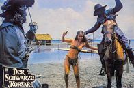 Der Schwarze Korsar – Der Schwarze Korsar (Kabir Bedi, li.) rettet das Mädchen Yara (Sonja Jeanine, Mi.), als ihr Dorf überfallen wird.