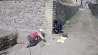 Schätze des Römischen Reichs – Die Archäologiestudentin Beatrice Lanteri und die Archäologieprofessorin Antonella Coralini untersuchen Beweise für ein mögliches Tieropfer, das unter einer Straße in Pompeji vergraben war. (Kredit: National Geographic/Annamaria Craparotta)