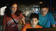 Die Pfefferkörner – Leo (Charlotte Farhadi), Hakim (Mads Albatros) und Moritz (Jan Friedrichsen) fragen sich, was Amy am Computer recherchiert haben könnte.