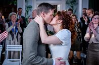 Sturm der Liebe – ARD STURM DER LIEBE FOLGE 4660 Uhr im ERSTEN. Fanny (Johanna Graen r.) und Marlon (Frederik Bott l.) geben sich bewegt das Ja-Wort. Alle Freunde und Kollegen klatschen beim Kuss begeistert.