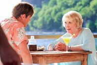 Death in Paradise – Humphrey (Kris Marshall, l.) und Tante Mary (Wendy Craig, r.) sitzen bei einem Cocktail beieinander. Mary hat ihrem Neffen etwas Wichtiges mitzuteilen.