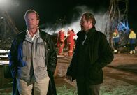 Mankells Wallander – Fassungslos beobachten Kommissar Wallander (Krister Henriksson) und sein Kollege Martinsson (Douglas Johansson) das Elektrizitätswerk, das durch einen Sprengstoffanschlag zerstört wurde.
