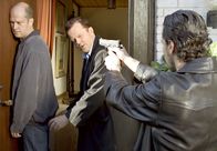 Mankells Wallander – Kommissar Wallander (Krister Henriksson, Mitte) und sein Kollege Stefan Lindman (Ola Rapace, rechst) verhaften den Familienvater Albert Schyberg (Magnus Mark) wegen Mordes.