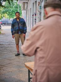 neoriginal: Späti – Rashid (Falilou Seck, l.) beobachtet Herrn Elster (Gunnar Helm, r.), der auf dem Gehweg vor dem Späti steht.