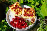 Zu Tisch ... – Zum Mittagessen gibt es Schmierschelkuchen, eine deftige Spezialität mit Kartoffelbrei, Schmand, Speck und Zwiebeln. Dazu wird Rote-Bete-Salat gereicht.