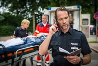 Notruf Hafenkante – Melanie (Sanna Englund, l.) hat im Einsatz ein Mädchen (Amina Merai, M.) angefahren. Mattes (Matthias Schloo, r.) gibt den Kollegen vom Revier die Daten durch.