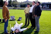 Der Bulle von Tölz – Am Tatort wird Mayr (Florian Münzer, l.) von Benno (Ottfried Fischer, 2.v.r.) und Philipp (Felix Eitner, r.) zu dem ermordeten Gustl Brunner (Franz Buchrieser, 2.v.l.) befragt.