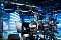 Die Welt am Abend – Professionelle Ausstattung in einem blauen Fernsehnachrichtenstudio. Beleuchtungsgeräte und Videokameras auf einem Stativ.