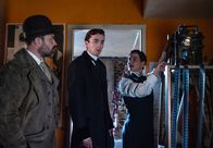 Vienna Blood – Die Regisseurin Rosa Koller (Bibiana Beglau, r.) zeigt im kleinen Vorführraum des Theaters Oskar Rheinhardt (Juergen Maurer, l.) und Max Liebermann (Matthew Beard, M.) einen Filmausschnitt.