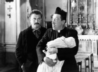 Don Camillo und Peppone – Don Camillo (Fernandel, r) weigert sich, das Baby seines Lieblingsfeindes Peppone (Gino Cervi) zu taufen.