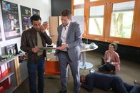 Die Rosenheim-Cops – Während Rechtsmedizinerin Dimos (Anastasia Papadopoulou, r.) die Leiche (Komparse) untersucht, begutachten die Kommissare Kaya (Baran Hęvî, l.) und Hansen (Igor Jefti?, M.) eine Zeitung, die mit einer Drohung versehen wurde.