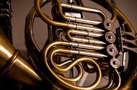 Horizont – Close up detail of the brass tubing and valves of a French horn in a music concept