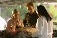 CSI: Miami – Die Gerichtsmedizinerin Alexx Woods (Khandi Alexander, r.) zeigt Calleigh (Emily Procter) und Horatio (David Caruso) eine Eintrittswunde in der Brust des Piloten. Wurde er erschossen? Wer hatte die Waffe mit an Bord?