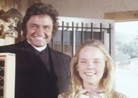 Unsere kleine Farm – Mary (Melissa Sue Anderson, r.) hat keine Ahnung, dass Mr. Hodgekiss (Johnny Cash, l.) kein Priester ist und hilft ihm gerne beim Sammeln der Spendengelder.