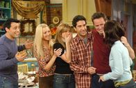 Friends – Monica (Courteney Cox, r.) ist ziemlich sauer, weil ihre Freunde, Joey (Matt LeBLanc, l.), Phoebe (Lisa Kudrow, 2.v.l.), Rachel (Jennifer Aniston, 3.v.l.) und Ross (David Schwimmer, 3.v.r.) zum alljährlichen Thanksginving-Essen viel zu spät gekommen sind. Doch die Tatsache, dass Monica und Chandler (Matthew Perry, 2.v.r.) ein Adoptivkind bekommen, lässt sie alles vergessen ...