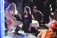 Castle – Kate Beckett (Stana Katic, M.) muss die Show des Strippers leider unterbrechen. Richard Castle (Nathan Fillion, hinten r.) amüsiert sich über den gelungenen Auftritt seiner Kollegin.
