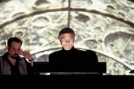 Die Truman Show – Der Verantwortliche der Truman Show ist Christof (Ed Harris, r.), Erfinder, Produzent und Regisseur. Alle Darsteller sind Schauspieler, nur der Star glaubt, am wirklichen Leben teilzunehmen ...