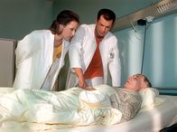 In aller Freundschaft – MDR Fernsehen IN ALLER FREUNDSCHAFT FOLGE 18, "Stunden der Entscheidung" Uhr. Maia Dietz (Ina Rudolph, li.) und Achim Kreutzer (Joachim Kretzer) untersuchen Helmut Grosser (Peter Pauli).