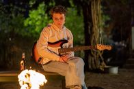 Jenseits der Spree – Stella (Luna Jordan), Roberts mittlere Tochter sitzt gedankenversunken am Lagerfeuer. Sie ist traurig, dass ihr Vater nicht mehr so viel Zeit für die Familie hat.