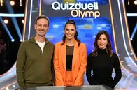 Quizduell - Olymp – Moderatorin Esther Sedlaczek (M.) mit den Kandidat:innen des Teams "Kamera": Dem Schauspieler Jörg Hartmann (l.) und der Schauspielerin Aylin Tezel (r.).