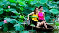 alpha-expedition / Länder-Menschen-Abenteuer: Mit dem Zug ... – Der Westlake am Stadtrand von Hanoi war schon immer Anziehungspunkt, für Pärchen, die der Großstadt entfliehen wollten, für Picknick und Romanzen. Diese beiden Damen lassen sich inmitten des Blumenmeers fotografieren.