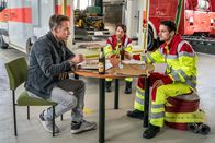 SOKO Leipzig – Jan Maybach (Marco Girnth, l.) spricht bei einer gemeinsamen Pizza mit seinem Sohn Benni Maybach (Maximilian Klas, M.) und dessen Kollegen Lukas Schaaf (Philip Birnstiel, r.) über die Herausforderungen, die die Rettungssanitäter täglich zu bewältigen haben.