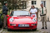 Hubert und Staller – Hubert (Christian Tramitz, rechts) und Staller (Helmfried von Lüttichau, links) begutachten das Auto von Schönheitschirurg Dr. Fritz Bähr (Sebastian Goder, Mitte).