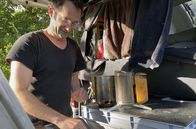 Trend Mikro-Urlaub - Campervan und Schrebergarten – Ben Wawra, den Chef von Spacecamper, am Heck seines Vans in dem er auch wohnt, beim Kaffee kochen.