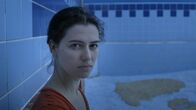 Swimmingpool am Golan – Die Filmemacherin Esther Zimmering begibt sich in Berlin und Israel auf die Suche nach den großen Ideen des Sozialismus, denen ihre Vorfahren gefolgt sind und stößt auf Konflikte und Geheimnisse. Sowohl auf israelischer als auch auf ostdeutscher Seite tauchen politisch brisante Lücken in den Biographien der Familien auf. - Esther Zimmering im leeren Swimmingpool in Israel/Kibbuz Kfar Szold.