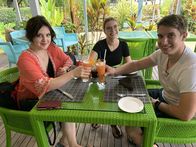 Verrückt nach Meer – Die Praktikanten Theresa, Lena und Daniel (von links) flüchten sich auf der Seychellen-Insel La Digue vor dem Regen in eine Bar und geniessen einen Cocktail bei bester Laune.