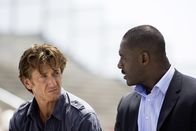 Gunman – Agent Barnes (Idris Elba, r.) spricht Jim Terrier (Sean Penn, l.) an, weil er sich von ihm Informationen erhofft.