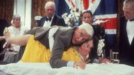 Die nackte Kanone – Der ungeschickte Lt. Frank Drebin (Leslie Nielsen, oben) versucht ein Attentat auf die britische Königin Elizabeth II. (Jeannette Charles, unten) zu vereiteln.